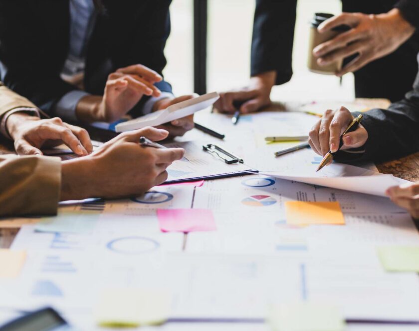 Händer som håller dokument och pennor